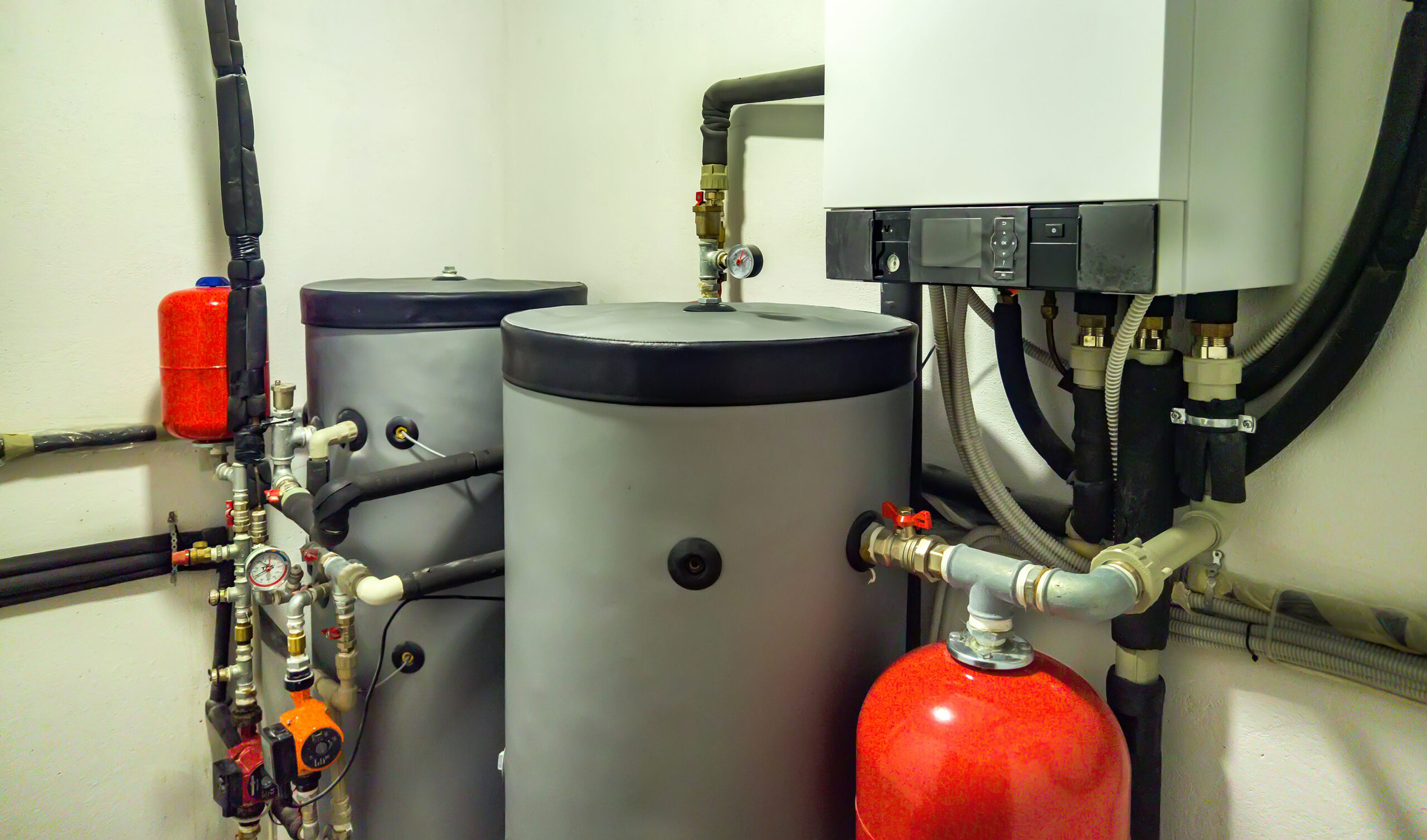 %Imagetitle% | Aaa Service Network AAA Service Network utility room featuring two large water tanks, a control unit, pipes, gauges, and a red expansion tank.